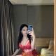 Attractive Malaysian woman in red lingerie taking a selfie.
